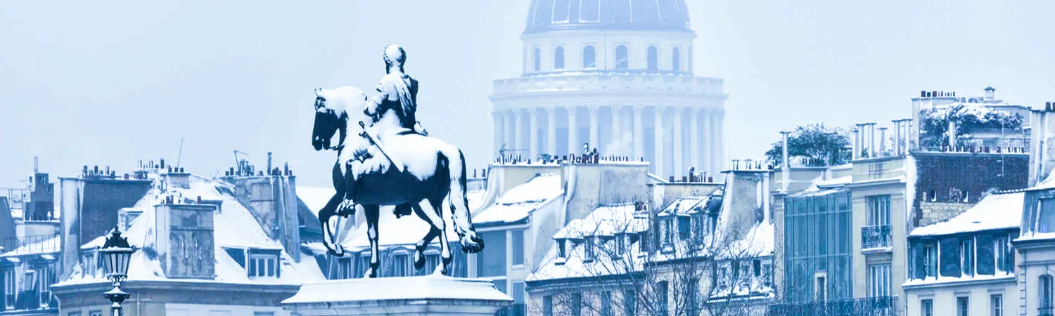 A snowy cityscape featuring a prominent equestrian statue, classic architecture, and rooftops covered in snow.